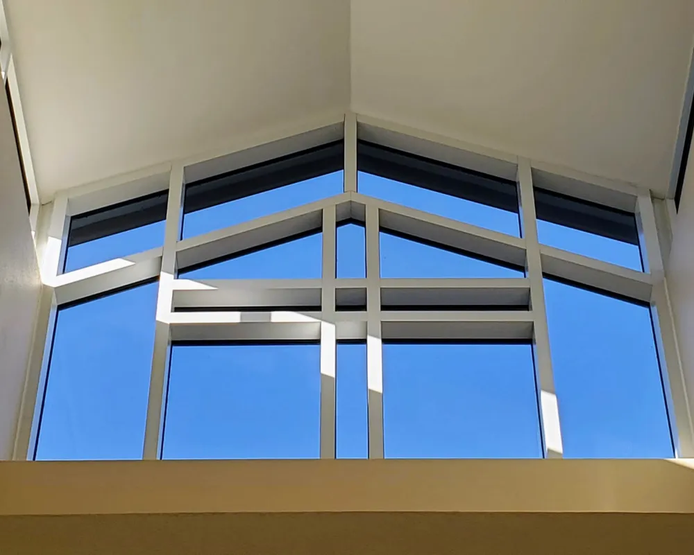 A clerestory window in the shape of a cross located in the fellowship hall
