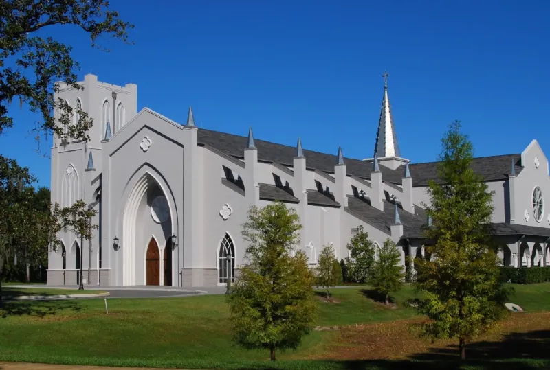 The white, steepled exterior of Saint Andrew's Chapel beneath a clear blue sky